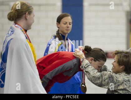 Team Marine Corps Mitglied Lance Cpl. Kira Lavine, in Rot, erhält die Goldmedaille in der 50 Meter Freistil schwimmen Konkurrenz von US Air Force Generalleutnant Gina M. Grosso, Kommandant der DoD Krieger Spiele, 8. Juni 2018. Team Armee Mitglied SPC. Angela Euson gewann die Silbermedaille und Team's Air Force Master Sgt. Linn Dillard gewann die Bronzemedaille. Der Krieger Spiele, statt Juni 1-9, bei der US Air Force Academy in Colorado, sind ein paralympic - style Wettbewerb für die Verwundeten und verletzten Service Mitglieder aus allen US-amerikanischen Filialen der Service und sind in diesem Jahr Mannschaften aus dem Vereinigten Königreich Bewaffneten Stockfoto