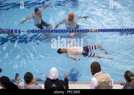 Team "SOCOM"-Veteran Kapitän James Howard konkurriert im 2018 DoD Krieger spiele Schwimmen Wettbewerb von Anhängern und Wettbewerber im Rennen in der Air Force Academy in Colorado Springs, Colo. Juni 8, 2018 umgeben. Stockfoto