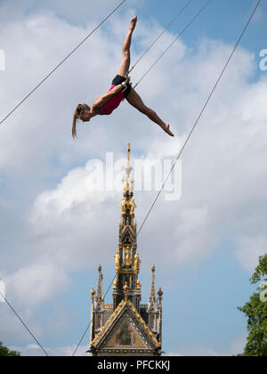 London, Großbritannien. 21 August, 2018. Junge Frauen Keep Cool in 27 c Hitze, indem sie über das Albert Memorial in Kensington, London zu fliegen. Sie sind Sie Training mit dem Fliegenden Trapez Schule (www.gorillacircus.com) Credit: David Thorpe/Alamy leben Nachrichten Stockfoto