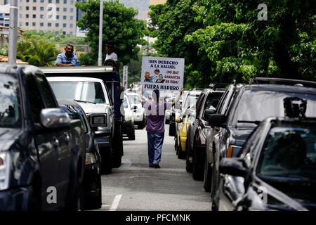 Valencia, Carabobo, Venezuela. 21 Aug, 2018. August 21, 2018. Ein junger Mann Spaziergänge zwischen einer Linie der Autos während eines Protestes gegen die wirtschaftlichen Maßnahmen durch den venezolanischen Präsidenten Nicolas Maduro. In Valencia, Carabobo Zustand. Foto: Juan Carlos Hernandez Credit: Juan Carlos Hernandez/ZUMA Draht/Alamy leben Nachrichten Stockfoto