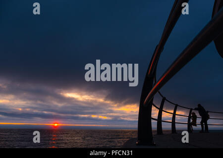 Aberystwyth Wales UK, Dienstag, 21. August 2018 Großbritannien Wetter: Menschen auf Aberystwyth Strandpromenade sind gegen die Rötung Himmel bei Sonnenuntergang Silhouette wie in Großbritannien in Richtung August Bank Holiday Wochenende Foto: Keith Morris/Alamy leben Nachrichten Stockfoto