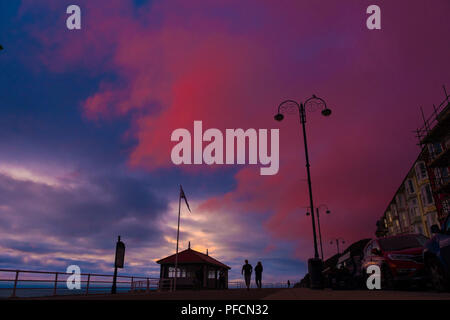 Aberystwyth Wales UK, Dienstag, 21. August 2018 Großbritannien Wetter: Menschen auf Aberystwyth Strandpromenade sind gegen die Rötung Himmel bei Sonnenuntergang Silhouette wie in Großbritannien in Richtung August Bank Holiday Wochenende Foto: Keith Morris/Alamy leben Nachrichten Stockfoto