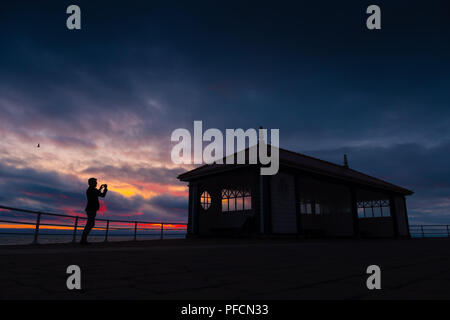 Aberystwyth Wales UK, Dienstag, 21. August 2018 Großbritannien Wetter: Menschen auf Aberystwyth Strandpromenade sind gegen die Rötung Himmel bei Sonnenuntergang Silhouette wie in Großbritannien in Richtung August Bank Holiday Wochenende Foto: Keith Morris/Alamy leben Nachrichten Stockfoto