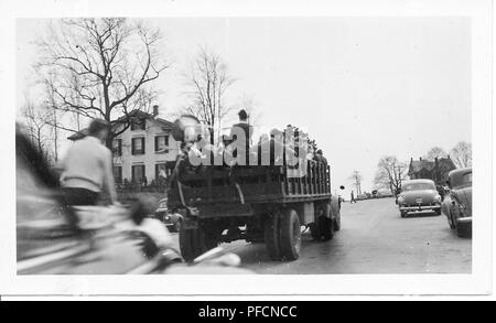 Schwarz-weiß Foto, zeigt die Rückseite eines offenen Lkw entfernt. Laufwerke, die Ladefläche ist mit Mitgliedern einer Militärkapelle gefüllt, einige Holding Hörner, mit kahlen Bäumen, Oldtimer, und Häuser auf beiden Seiten der Straße sichtbar, wahrscheinlich in Ohio während der Feierlichkeiten zum Ende des Zweiten Weltkrieges, 1945 fotografiert. () Stockfoto