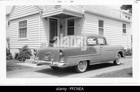 Schwarz-weiß Foto, zeigt ein zweifarbiges, Hardtop, Chevrolet Bel Air in einer Fahrstraße vor einem kleinen, hellen Haus geparkt, mit Abstellgleis und eine überdachte Veranda, wahrscheinlich in Ohio, August, 1955 fotografiert. () Stockfoto