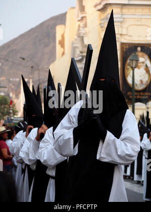 Hooded devotee, von unserer Dame der Einsamkeit Bruderschaft, in eine religiöse Prozession am Karfreitag, als Teil des 2018 Feierlichkeiten zur Karwoche in Lima Stockfoto