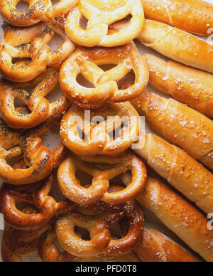 Weiche Brezeln garniert mit Mohn und Salz, Grissini mit Salz bestreut Stockfoto