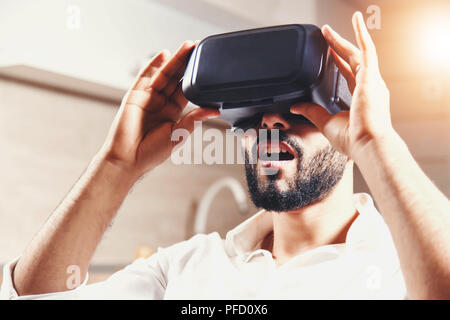Eine VR-Brille multikulturellen bärtigen Player suchen mit offenem Mund erstaunt suchen Stockfoto