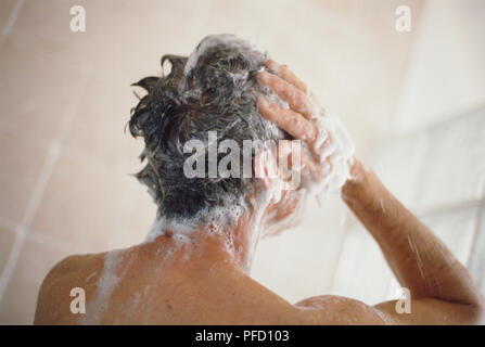 Mann unter der Dusche und Waschmaschine sein Haar Stockfoto