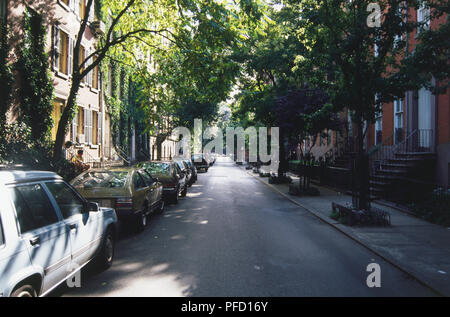 USA, New York, Manhattan, Greenwich Village, von Bäumen gesäumten Straße mit Autos auf einer Seite geparkt. Stockfoto