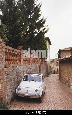 Italien, Toskana, San Gimignano, alten Fiat 500 durch die Wand in der Seitenstraße geparkt Stockfoto