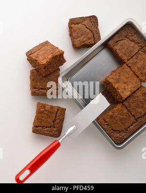 Chocolate brownies in und neben dem Backblech und einen Kuchen Spachtel Stockfoto