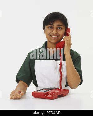 Frau in der Uniform der Krankenschwester am Telefon lächeln Stockfoto