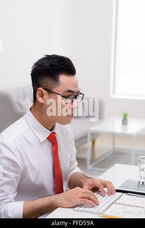 Profil anzeigen von einem gutaussehenden jungen Mann dabei einige Meditationsübungen, während Sie im Büro arbeiten Stockfoto