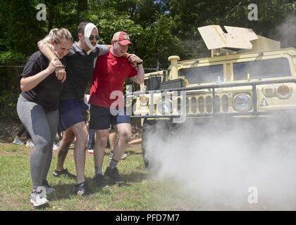 Strand, Virginia (1. Juni 2018) - Hospitalman Rachel Daniels, Links, und Hospitalman Shane Miller, rechts, Admiral Joel T. Boone Zweig Gesundheit Klinik zugeordnet, assist Walking mock Patient von einem Szenario während der corpsman Fähigkeiten Herausforderung an gemeinsamen Expeditionary Base Little Creek - Fort Story. Die corpsman Fähigkeiten Herausforderung Szenarien wurden auf realen Ereignissen Wissen des corpsman und ihre Fähigkeit unter dem Druck einer hohen Beanspruchung Umgebung durchführen zu testen. Stockfoto