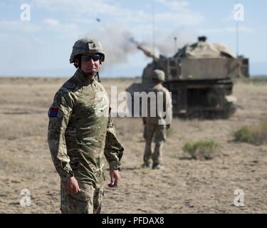 Staff Sgt. Lee Hamlett von der 103 (Freiwillige) Lancashire Artillerie Regiment Royal Artillery, steht als 1-148 th Field Artillery Regiment M109A6 Paladin feuert eine 155 mm runde im Orchard Combat Training Center Juni 8, 2018. Hamlett, ein Mitglied der Reserven der Britischen Armee, verbrachte zwei Wochen Training mit dem Idaho Army National Guard Einheit als Teil der Army National Guard militärische Reserve Exchange Programm. Er war einer von sieben Mitgliedern der britischen Armee in das Programm während der 116 Kavallerie Brigade Combat Team exportierbar Combat Training Funktion Drehung zu patriziates. Stockfoto