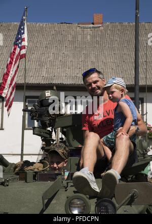 Eine einheimische Familie klettert an Bord einer US Marine Corps leicht gepanzerten Fahrzeug während der multinationalen ziviles Engagement Zeremonie in Bauska, Lettland, 2. Juni 2018, als Teil der Übung Sabre Streik 2018. Bürger aus der Gemeinschaft von Bauska wurden aufgefordert, mit den US-Marines und lettische Soldaten aus dem Lettischen nationalen Schutz 53 Infanterie Bataillon zu interagieren und ihre militärische Fahrzeuge tour. Die 4. LAR Marines führte eine Straße vom Hafen von Klaipeda, Litauen, Lieferungen und Ausrüstung, die für die Ausbildung im Bereich Adazai, Lettland zu liefern, während die Durchführung einer Reihe von Static Display Events in einem Stockfoto