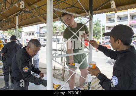 PUERTO PRINCESA, Republik der Philippinen (5. Juni 2018) Lance Cpl. Christipher Macauley, Zentrum, neben Mitgliedern der Barangay San Pedro Polizei Malerei ein Warten auf eine Schule während einer Community Relations event Halle. Mehr als 40 Mitglieder der Siebten Flotte Mitarbeiter sind derzeit schiffte sich auf usns Millinocket (T-EPF 3) besuchen mehrere Länder in der indopazifischen Region als Teil einer 7 Flotte theater Sicherheit Zusammenarbeit patrouillieren. Stockfoto