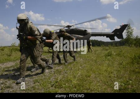 Österreichische Soldaten in den 6 Tank Firma zugewiesen, 14 Panzer Bataillon, Ausführen von UH-72A Lakota, durch US-Soldaten betrieben Delta Unternehmen, 1.BATAILLON, 376 Aviation Regiment, Nebraska Nationalgarde zugewiesen, als Teil einer medizinische Evakuierung während der starken Europa Tank Herausforderung (SETC) im 7. Armee den Befehl Grafenwöhr Training Area, Deutschland, 5. Juni 2018. Us-Army Europe und die deutsche Armee Gastgeber der dritten starkes Europa Tank Herausforderung bei Grafenwöhr Training Area, Juni 3 - 8, 2018. Die starke Europa Tank Herausforderung ist eine jährliche Veranstaltung, die Teilnehmenden zu geben Stockfoto