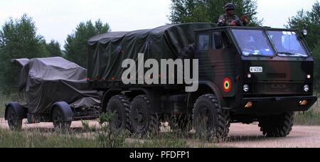 Die rumänische Armee Soldat mit Battle Group Polen, bietet Sicherheit von der Spitze eines rumänischen Armee Transport-LKW, wie es schleppt ein anti-aircraft System während einer raschen Reaktion Übung im Rahmen der Teilnahme an Sabre Streik 18 an der Bemowo Piskie, am 11. Juni 2018. Sabre Streik 18 ist der achte Iteration des langjährigen US-Army Europe - LED-kooperative Ausbildung übung, die Interoperabilität zwischen den Verbündeten und Partnern in der Region zu verbessern. (Michigan Army National Guard Stockfoto