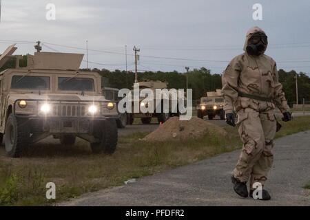 Gemeinsame Basis CAPE COD, Massachusetts - Army Staff Sgt. Melanye Ramirez, eine chemische, biologische, radiologische und nukleare Facharzt mit der 272 Chemical Company Massachusetts Army National Guard, Leitfäden Fahrzeuge zu einem dekontaminationsplatzes. Die Schulung ist Teil einer kombinierten Waffen ausüben, welche Tests die Mission Bereitschaft der Combat support Einheiten hier Juni 10, 2018. (Massachusetts Army National Guard Stockfoto