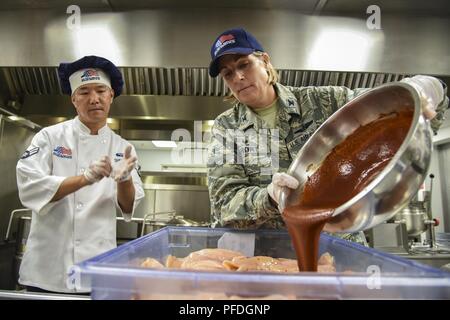 Kol. Jennifer Kurz, rechts, 23d Wing Commander, gießt Soße auf Huhn während einer Immersion tour, 11. Juni 2018, bei Moody Air Force Base, Ga. Kurze und Chief Master Sgt James Allen, 23 d WG Befehl Chief, bereiste die Georgia Kiefern Speisesaal und die Informationen Learning Center ein besseres Verständnis Ihrer gesamten Mission, Fähigkeiten und umfassende Aufgaben zu gewinnen. Stockfoto