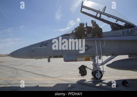 Oberstleutnant Jeremy Yauck (links), F/A-18 Hornet Pilot mit Marine Fighter Attack Squadron 112, Marine Flugzeuge Gruppe 41, 4 Marine Flugzeugflügel, zeigt die Funktionen des F/A-18 Hornet zu Marines mit Marine Light Attack Helicopter Squadron 775, während integrierte Ausbildung Übung 4-18 bei Marine Corps Air Ground Combat Center Twentynine Palms, Kalifornien, 10. Juni 2018. ITX 4-18 bietet MAGTF Elemente eine Gelegenheit, einen Service Level Bewertung der Kernkompetenzen, die sich auf Auslandseinsätze sind unerlässlich, um zu unterziehen, Vorwärts - bereitgestellt. Stockfoto