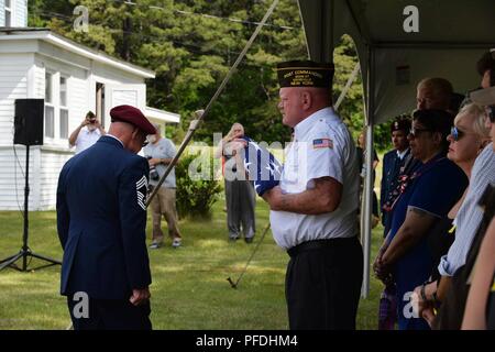 Pensionierten New York Air National Guard 106 Rettung Flügel Chief Master Sgt. Mike McManus, pararescueman NCOIC, gibt die gefaltete amerikanischen Flagge der VFW 1505 Kommandant Herr Mike Billinger, Keeseville, N.Y., 13. Juni 2018. Am 13. Juni 1978, eine HH-3E Jolly Green Giant Helikopter aus dem 102 für Luft- und Raumfahrt Rescue & Recovery Gruppe jetzt die 106 Rettung Flügel in Westhampton Beach N.Y., wieder zur Basis nach dem Training am Plattsburgh Air Force Base, NEW YORK, nach der Begegnung mit schlechtem Wetter, die sieben Mitglieder wandten sich nach Plattsburgh, aber mit geringen Sichtbarkeit, die HH-3E schlagen die Trembleau Berg nur Stockfoto