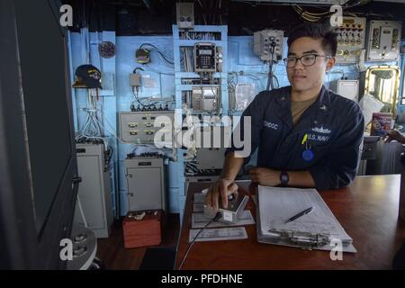 Philippinischen MEER (13. Juni 2018) Quartermaster 2. Klasse Ziolan Bondoc, aus Riverside, Kalifornien, unterstützt die Navigation in der Brücke der Ticonderoga-Klasse geführte-missile Cruiser USS Antietam (CG54) während der Übung Malabar. Malabar 2018 ist der 22. Wiedergabe der Übung und das erste Mal wurde Hosted vor der Küste von Guam, das Militär zu voraus-zu-militärische Koordination in einer multinationalen Umgebung zwischen den USA, Japan und die indischen Seestreitkräfte. Stockfoto