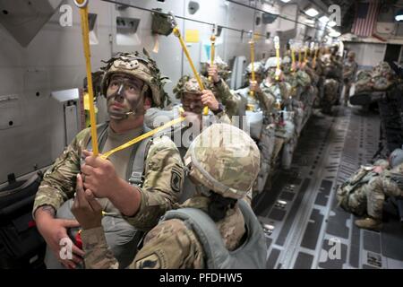 Mitglieder der US Army 1st Bataillon, 503Rd Infanterie Regiment, 173Rd Airborne Brigade für eine statische Zeile springen während der Übung Bajonett Streik Juni 13, 2018, über Julia Drop Zone, Italien vorbereiten. Der Sprung war mit Mitgliedern der Italienischen Armee 186th Airborne Regiment Forlgore Feuerwehr auf einer C-17 Globemaster III, durch 204. Airlift Squadron der Texas Air National Guard Betrieben statt. Die Ausbildung konzentriert sich auf die Verbesserung operativer Standards mit der NATO und anderen Air Mobility Command Flugzeuge sowie für die Entwicklung von einzelnen technischen Fähigkeiten. Stockfoto