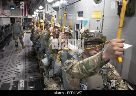 Mitglieder der US Army 1st Bataillon, 503Rd Infanterie Regiment, 173Rd Airborne Brigade für eine statische Zeile springen während der Übung Bajonett Streik Juni 13, 2018, über Julia Drop Zone, Italien vorbereiten. Der Sprung war mit Mitgliedern der Italienischen Armee 186th Airborne Regiment Forlgore Feuerwehr auf einer C-17 Globemaster III, durch 204. Airlift Squadron der Texas Air National Guard Betrieben statt. Die Ausbildung konzentriert sich auf die Verbesserung operativer Standards mit der NATO und anderen Air Mobility Command Flugzeuge sowie für die Entwicklung von einzelnen technischen Fähigkeiten. Stockfoto