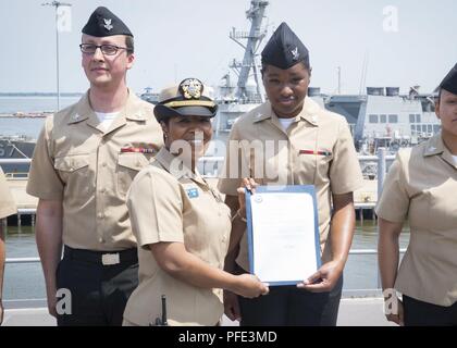 NORFOLK, Virginia (8. Juni 2018) - Elektroniker 2. Klasse Ona Corprew, von Virginia Beach, Virginia, auf USS Gerald R. Ford's (CVN 78) Combat Systems Abteilung zugewiesen, erhält Ihr frocking Brief von Lt.Cmdr. Satonya Braun, Combat Systems Wartung Ford's Officer, während der Werbeaktion Zeremonie an Bord des Schiffes. Stockfoto