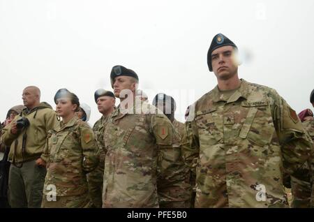 Sgt. Zachary Willis, Kommandierender General montiert Color Guard, 1 Infanterie Division (rechts), Adam Kralina, 1.Bataillon, 18 Infanterie Regiment, 2. gepanzerte Brigade Combat Team, 1. Inf. Div. (Mitte) und Pvt. 1. Klasse Alexandra Haught, 82nd Brigade Engineering Bataillon, 2 ABCT, 1. Inf. Div. (Links), stand durch eine plötzliche Regenschauer während des Charles Shay Gedenkveranstaltung in der Charles Shay Memorial, Saint-Laurent-sur-Mer, Normandie, Frankreich, 5. Juni. Die Zeremonie serviert Charles Shay, ein "Big Red One" Silver Star Empfänger und alle nativen amerikanischen Veteranen des Zweiten Weltkriegs zu ehren (Sgt. M Stockfoto