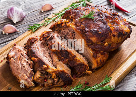 Grosses Stück langsam gekocht Oven-Barbecued zog Schweineschulter auf Schneidebrett mit gemischten Pfeffer, Rosmarin, Knoblauch, Chili auf Holzbohlen, Ansicht f Stockfoto