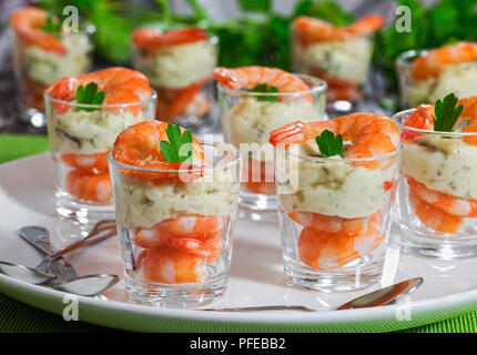 Einzelne Cocktail Shrimps Shot Gläser mit pikanter Sauce Tartar dekoriert mit Petersilie Blatt auf weiße Platte mit Grüns auf backround für Weihnachten di Stockfoto