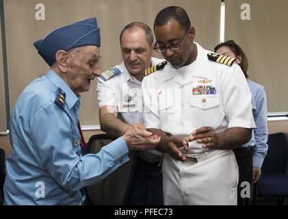 Rumänien (2. Juni 2018) Kapitän Charlos Washington, kommandierender Offizier für Naval Support Facility Deveselu, gibt einen Befehl Münze bis 99-jährige rumänische Generalmajor (A.D.) Ion Dobran, einem ehemaligen Zweiten Weltkrieg Deveselu Air Force Base Commander, während einer Tour, Juni 2. Dobran war berühmt für Abschuss amerikanische Pilot 1 Lt (Ret.) Barrie Davis, zu 325 Aviation Jagd Fraktion der US Army Air Forces, in der Nähe von Galati, Rumänien am 6. Juni 1944 vergeben. Während die USA und die Rumänische dogfight Davis war gezwungen, seinen Mustang P-51 Flugzeug in der Ukraine zu landen. Der amerikanische Pilot besucht Dobran 66 Jahre später im Janua Stockfoto