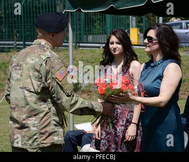 Us-Armee Sgt. Hunter Bischof, Landstuhl Regional Medical Center Unteroffizier des Jahres, Geschenke Blumen an Frau Mindi Charpentier (ganz rechts) bei Verzicht des Ehemannes der Verantwortung am 30. Mai 2018 in Landstuhl/Deutschland Stockfoto