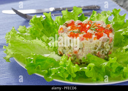 Olivier - lecker Kartoffelsalat mit Gurken und Gemüse, gekrönt mit rotem Kaviar - Traditionelle festliche Gericht in Russland und der Ukraine, Nahaufnahme, Ansicht f Stockfoto