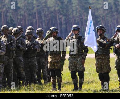 Als Teil der Sabre Streik 18, der rumänischen und der britischen Soldaten machen ein Gruß während dem Abspielen der Nationalhymnen von fünf der teilnehmenden Nationen in Wierzbiny, Polen am 4. Juni 2018. Sabre Streik 18 ist der achte Iteration des langjährigen US-Army Europe - LED-kooperative Arbeit, die Interoperabilität zwischen den Verbündeten und Partnern in der Region zu verbessern. (Michigan Army National Guard Stockfoto