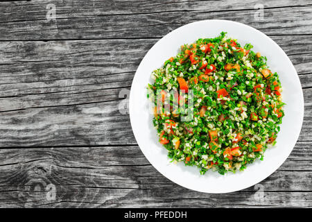 Tabbouleh Salat - im Nahen und Mittleren Osten vegetarisches Gericht mit Bulgur, Tomaten, Petersilie, Frühlingszwiebeln und Minze, einfache authentische Rezept, Ansicht von oben Stockfoto