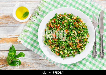 Petersilie Salat oder Tabbouleh, Naher Osten vegetarisches Gericht mit Bulgur, Tomaten, Petersilie, Frühlingszwiebeln und Minze, bestreut mit Olivenöl und Zitrone Stockfoto