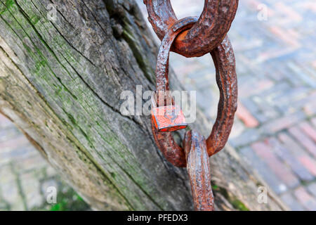 Nahaufnahme von einem kleinen Vorhängeschloss mit Herz an einem alten verwitterten Ankerkette im Hafen von Carolinensiel in Ostfriesland. Stockfoto