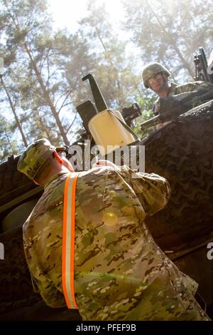 Us-Armee finden Sgt. Jody Galinat, Transport Koordinator mit 1172Nd Bewegung Control Team, 446Th Transport Bataillon, Grafenwöhr, Deutschland, erhält Waffen und Personal zählt von einem Konvoi mit 2d-Cavalry Regiment in der Nähe von Orzysz, Polen, während der übung Sabre Streik 18, Juni 4. Sabre Streik ist ein langjähriger US-Army Europe - led integrierte Übung, die hilft, die Zusammenarbeit zwischen den USA, Estland, Lettland, Litauen, Polen und 19 andere erleichtern und Partner der alliierten Nationen, Juni 3-15 Stockfoto