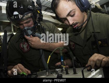 5 FLOTTE EINSATZGEBIET (5. Juni 2018) Marine Corps Sgt. Nicholas Gärtner, Links, und Marine Corps Cpl. Sebastian Douglass, sowohl für Marine Medium Tiltrotor Squadron (VMM) 162 (verstärkt), Fehlerbehebung Kommunikation zugeordnet und die Atmung Funktionalität auf dem HGU-84/P Flieger Helm im Flug Ausrüstung Arbeitsplatz an Bord der Wasp-Klasse amphibisches Schiff USS Iwo Jima (LHD7), 5. Juni 2018. Iwo Jima in Mayport, Fla. homeported, ist auf die Bereitstellung zu den USA 5 Flotte Bereich für Maßnahmen zur Erhöhung der Sicherheit des Seeverkehrs Operationen Verbündeten und Partnern zu beruhigen, und f erhalten Stockfoto