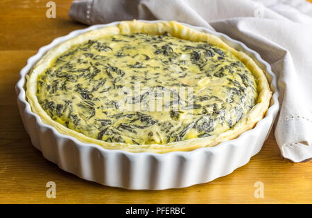 Spinat Tarte mit Eiern und Feta auf hölzernen Tischplatte Stockfoto