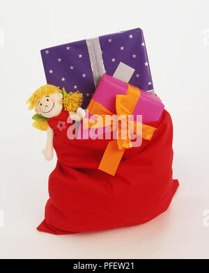 Rot Geschenk Sack mit eingewickelt und rag doll gefüllt. Stockfoto
