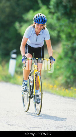 Weibliche Radfahrer, Land weg, lächelnd, sonniges Wetter. Stockfoto
