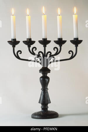 Reich verzierte schwarze Kandelaber mit fünf Kerzen, Vorderansicht. Stockfoto
