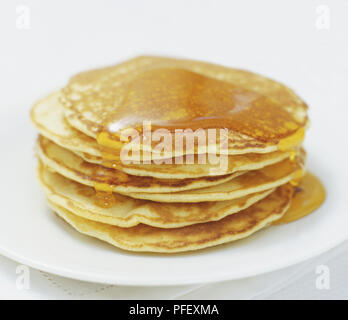 Pfannkuchen auf einer Platte gekrönt mit goldenen Sirup gestapelt, in der Nähe Stockfoto