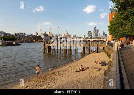 LONDON, Großbritannien - 6 August, 2018: Die Menschen auf den kleinen Strand am Ufer der Themse von Gabriel's Wharf auf Hauptstadt der South Bank von England mit Stockfoto